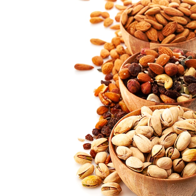 Three wooden bowls with different nuts  isolated on white background