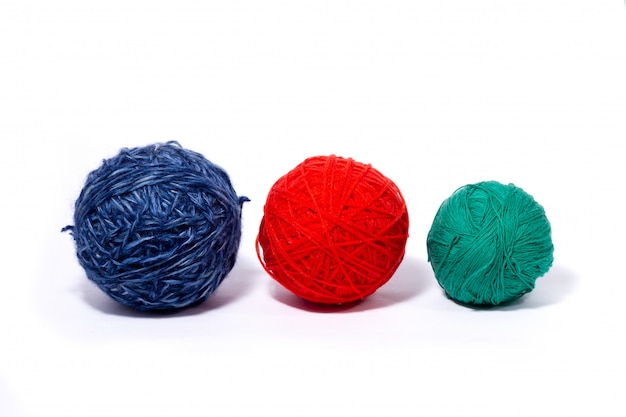 Three woolen skeins with multi-colored threads isolated on white wall