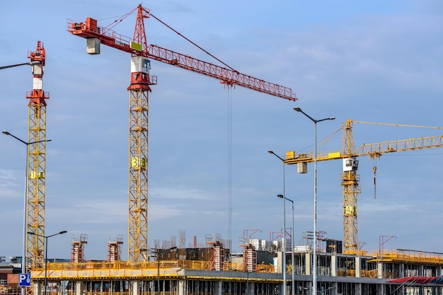 Three Yellow and Red Tower Cranes Under Clear Blue Sky Photo