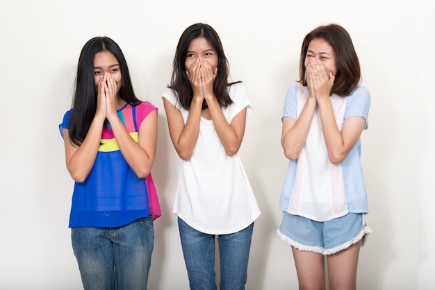 three young beautiful Asian teenage girls on white