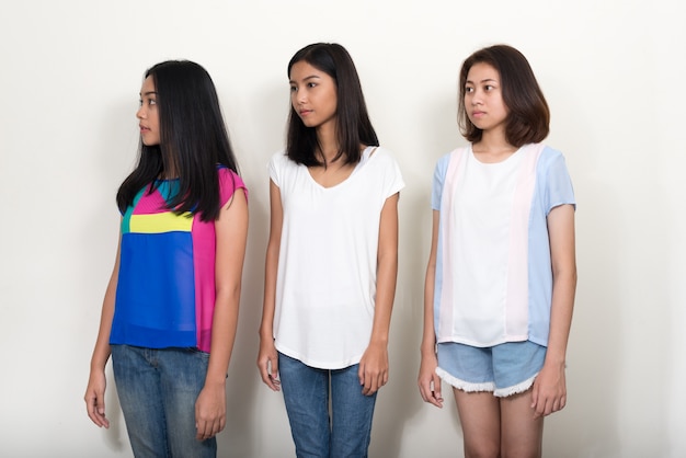 three young beautiful Asian teenage girls on white