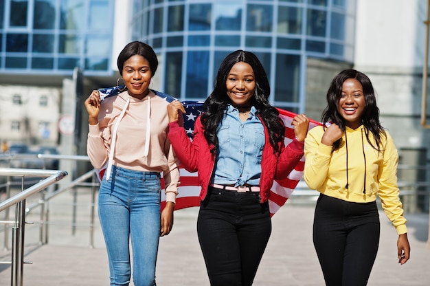 Three young college african american womans friends with flag of USA.