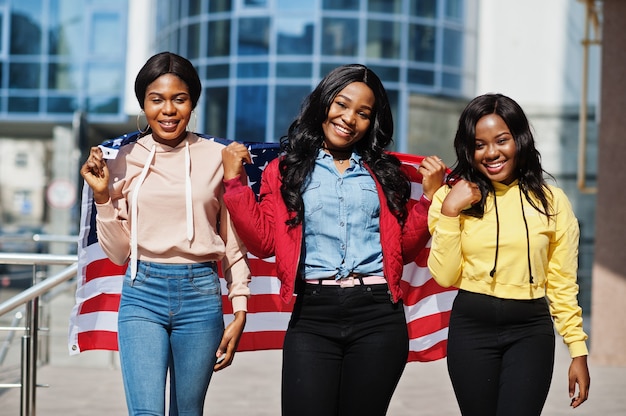 Three young college african american womans friends with flag of USA.