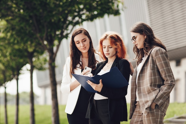 Three young stylish women working outdoors