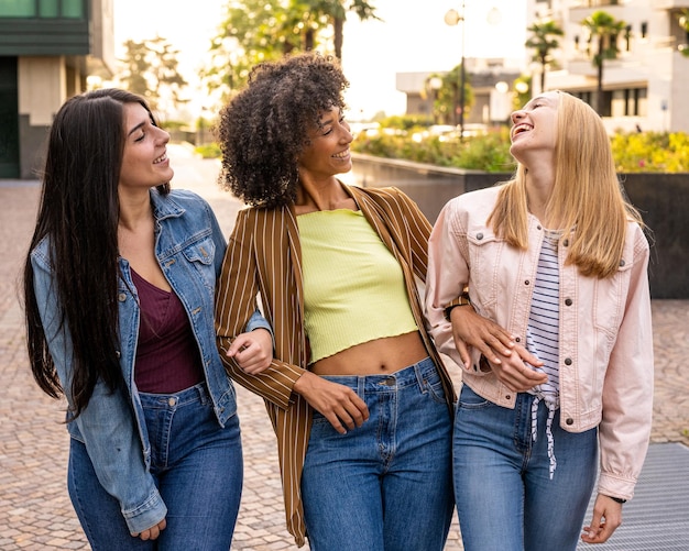 Three young women of generation z walking in the city summer vibes and happiness