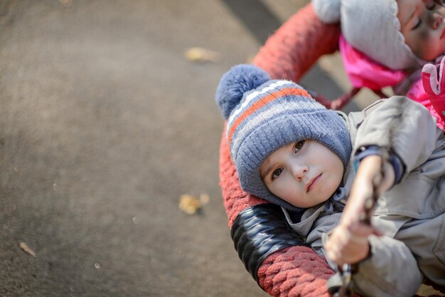 A threeyearold boy rides a swing on the playground