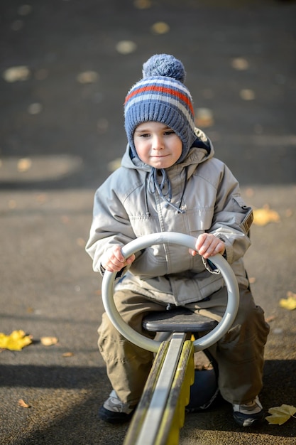 A threeyearold boy rides a swing on the playground