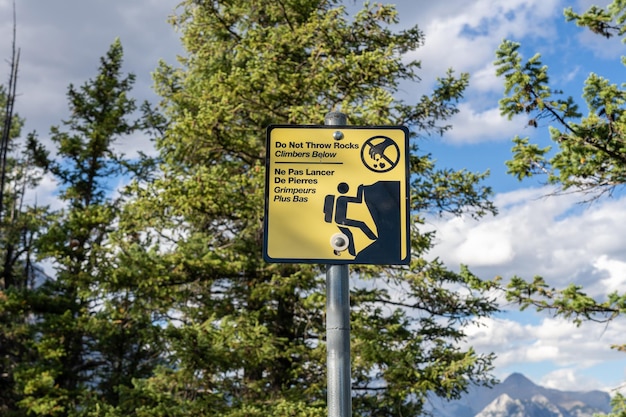 Do not throw rocks climbers below warning sign signpost at Trail Banff National Park