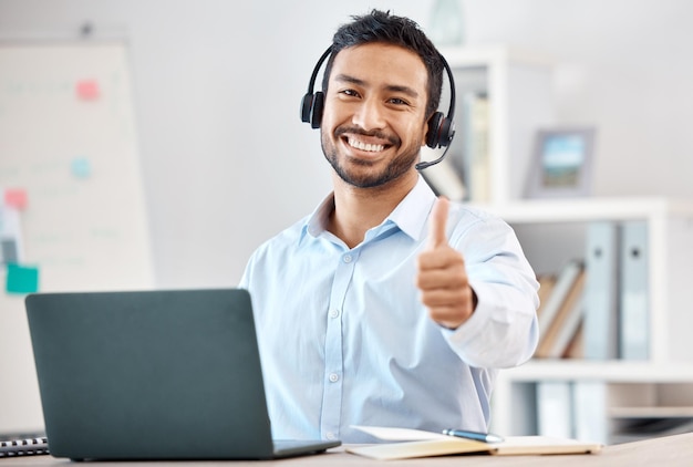 Thumbs up call center and customer service with a man saying thank you and working in sales or telemarketing Crm contact us and consulting with a male consultant giving a yes gesture in an office