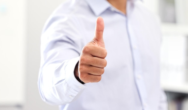 Thumbs up for celebrating success and good work hand of business man manager or entrepreneur showing hand gesture Closeup sign and positive symbol of approval agreement and trust on fingers