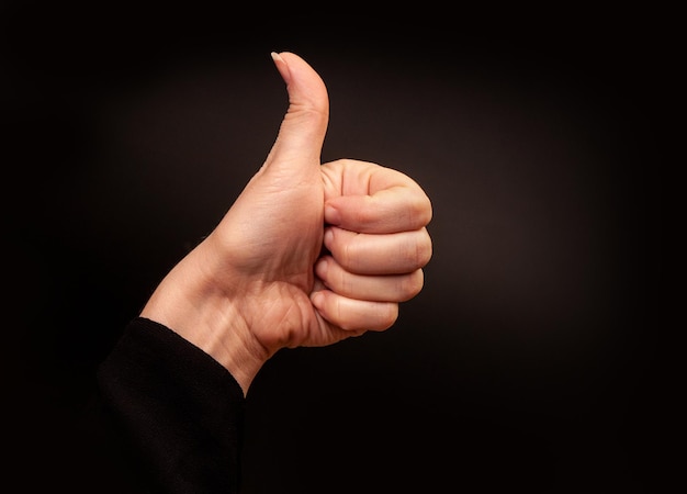 Thumbs up hand isolated on black background