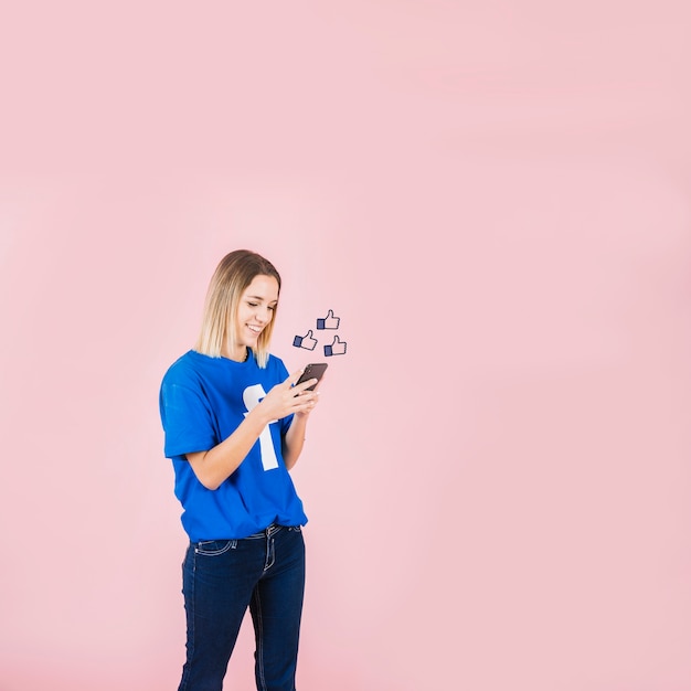 Thumbs up sign over happy woman using smartphone