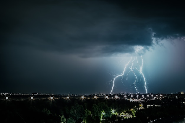 Thunderstorm front over the cities lightning strikes the ground storm