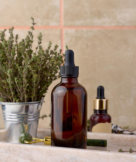 Thyme essential oil in glass bottle with dropper and fresh thyme sprigs on table cosmetic ingredient