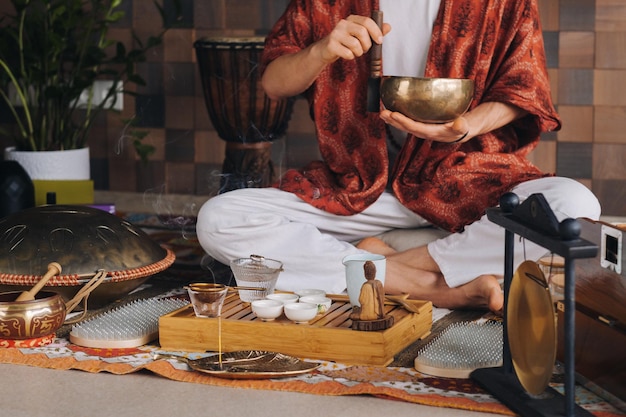 Tibetan singing bowl in the hands of a man during a tea ceremony