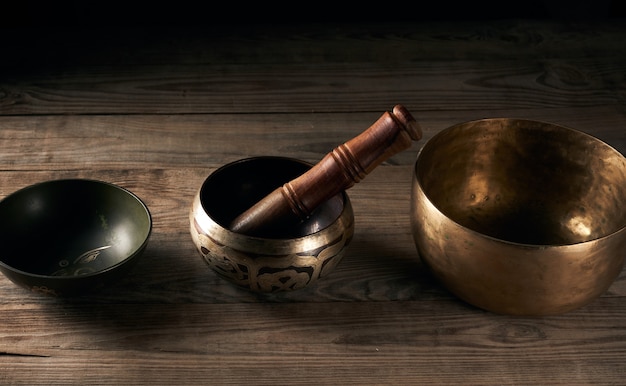 Tibetan singing copper bowl with a wooden clapper on a brown wooden table