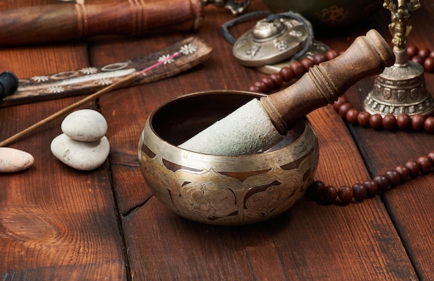 Tibetan singing copper bowl with a wooden clapper, objects for meditation and alternative medicine. Plunging into a trance