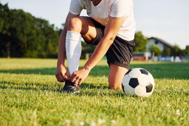 Ties laces Young soccer player have training on the sportive field