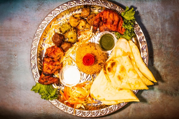 Tikka boti seekh kabab platter with pulao roti lime and salad in a dish top view of middle eastern barbeque dish