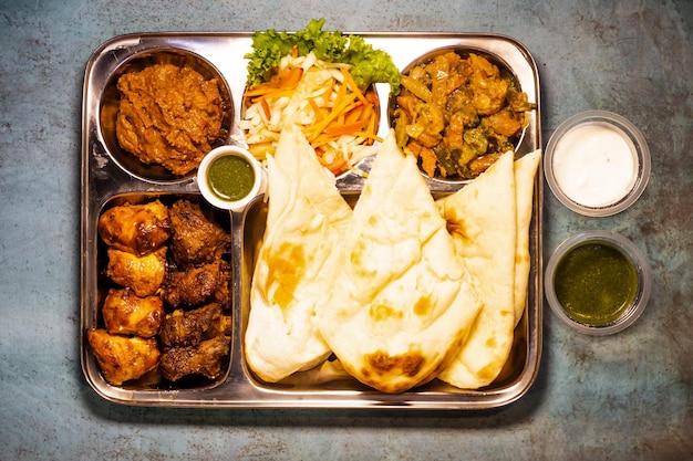 Tikka boti seekh kabab platter with pulao roti lime and salad in a dish top view of middle eastern barbeque dish