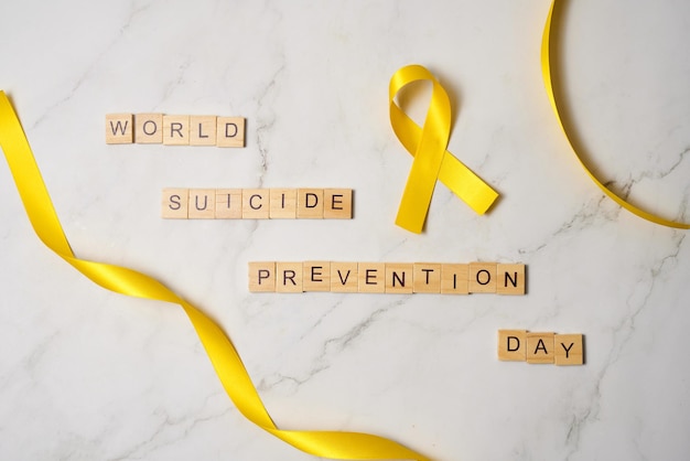 Photo tiles saying world suicide prevention day with yellow ribbon