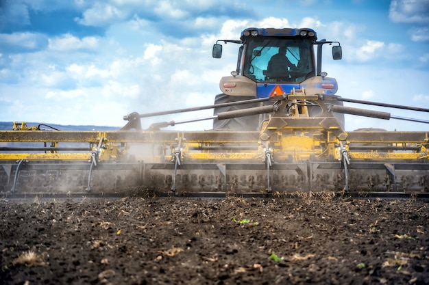 Tillage in the field with a tractor with a trailed machine.