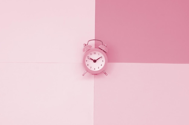 Time to choose metaphor concept Alarm clock at the crossroads of different colors Image toned in Viva Magenta color of the 2023 year