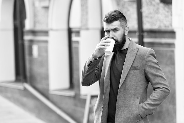 Time to drink Bearded man drinking morning coffee Hipster with disposable paper cup walking in city Businessman in hipster style holding takeaway coffee The best time of day to drink coffee