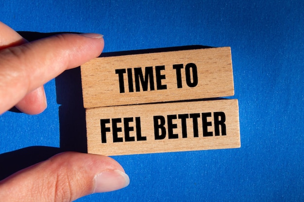 Photo time to feel better message written on wooden blocks with blue background conceptual time to feel better symbol copy space