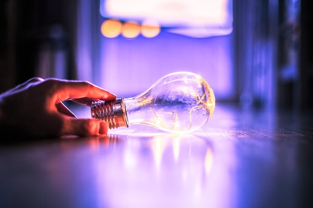 Time for ideas inspiration and invention Hands are holding a LED lightbulb