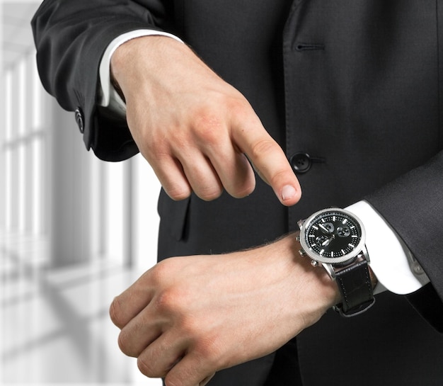 Photo time is money businessman pointing on watch business concept