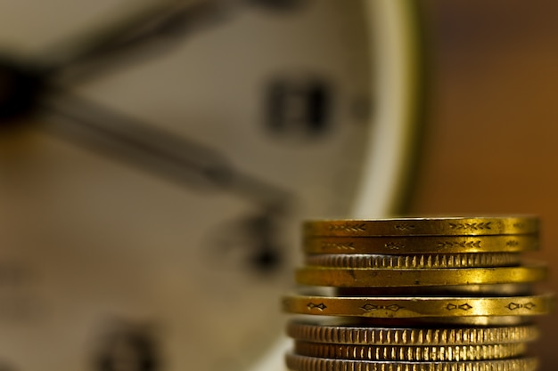 Photo time is money. close-up of stacked coins and an alarm clock. 