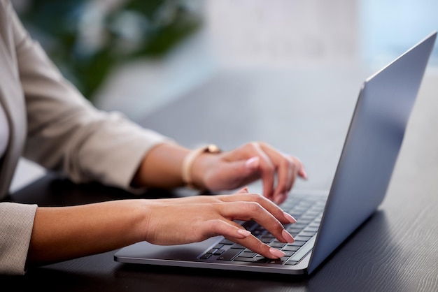 Time is money Cropped shot of a young businesswoman using a laptop at her desk in a modern office