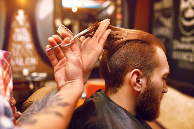 Time for a new hairdo. Handsome young bearded man came to the barber for a haircut. hipster style. the concept of fashion and beauty.