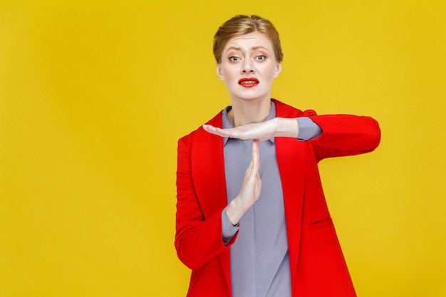 Time out unhappy business woman in red suit showing pause sign