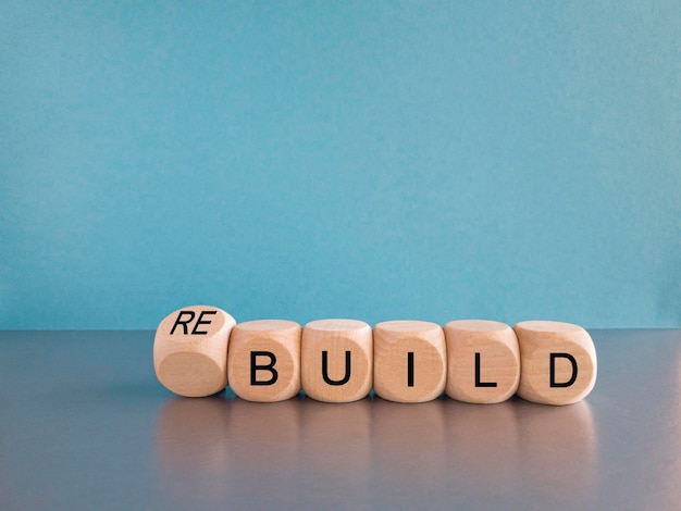 Time to rebuild symbol Turned wooden cubes and changes the word 'build' to 'rebuild'