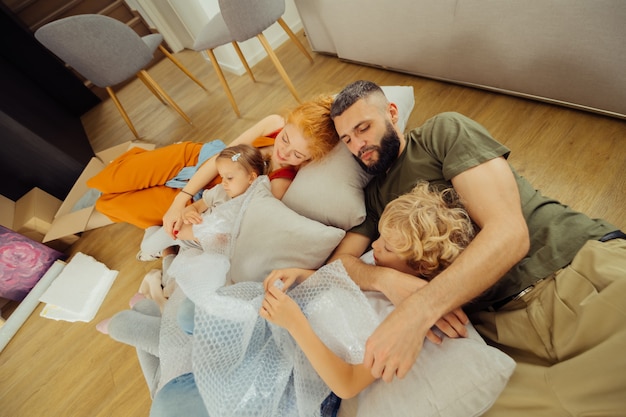 Time to rest. Nice happy family lying on cushions while sleeping together in the living room