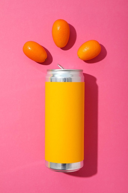 Tin can and kumquats on pink background top view