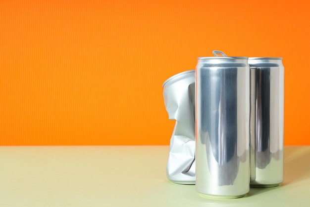 Tin cans for drinks on an orange background