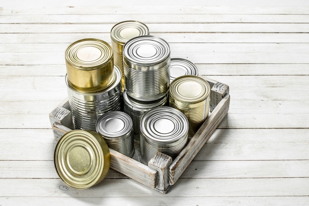 Tin cans with food in a box. 