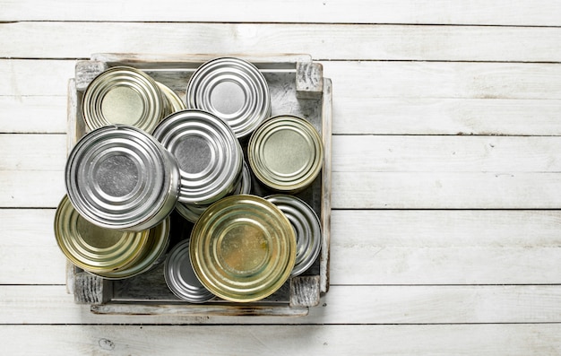 Tin cans with food in a box. 