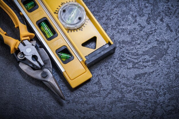 Tin snips construction level on black background