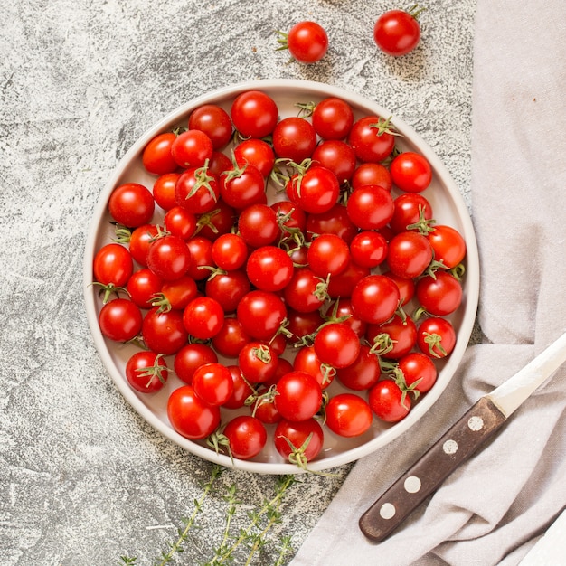 Tiny cherry tomatoes (ciliegini, pachino, cocktail). group of cherry tomatoes on a gray concrete  ripe and juicy cherry tomatoes