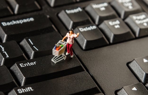 tiny miniature figurine woman with shopping cart 