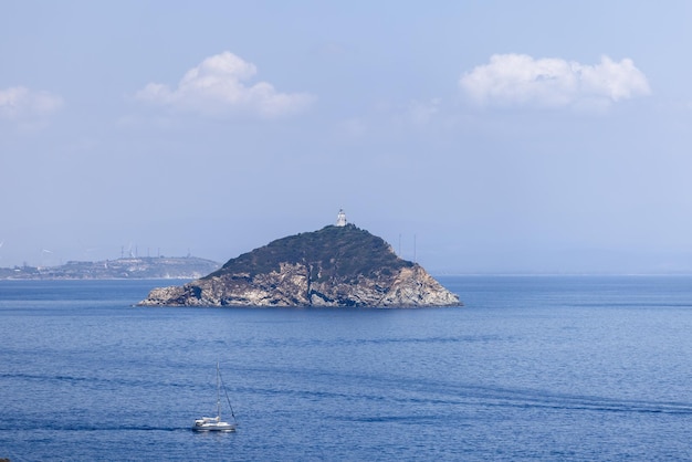 Tiny Palmaiola inlet has rocky and craggy cliffs, lighthouse of 105m high, Tuscan archipelago, Italy