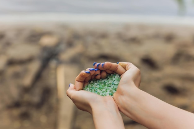 Tiny pieces of plastic collected from sandy beach in hands of environmentalist microplastic is pollu