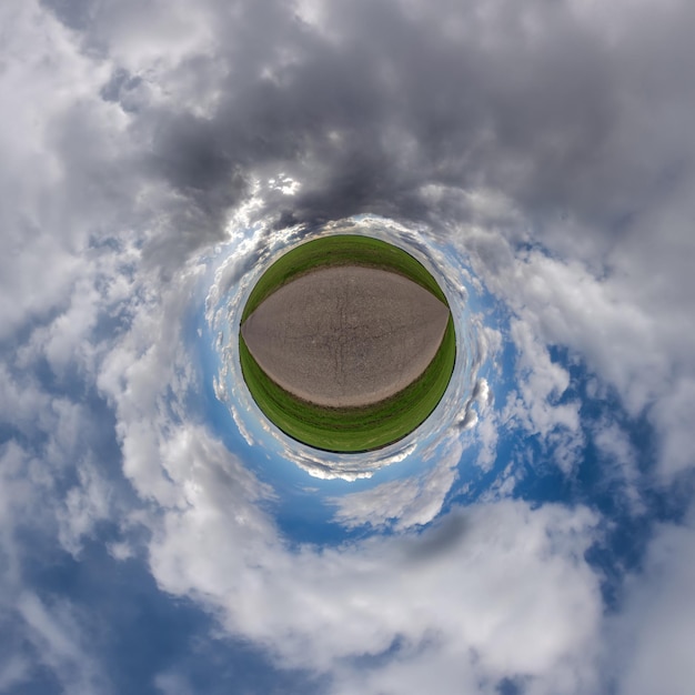 Tiny planet in blue overcast sky with beautiful clouds with transformation of spherical panorama 360 degrees Spherical abstract aerial view Curvature of space