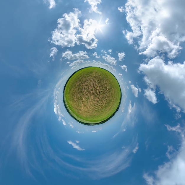 Tiny planet in blue overcast sky with beautiful clouds with transformation of spherical panorama 360 degrees Spherical abstract aerial view Curvature of space