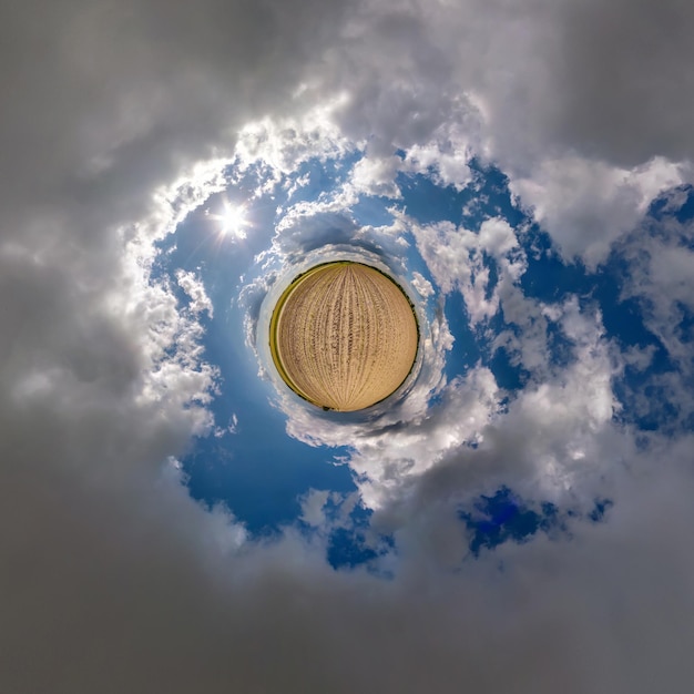 Tiny planet in blue sky with beautiful clouds Transformation of spherical panorama 360 degrees Spherical abstract aerial view Curvature of space