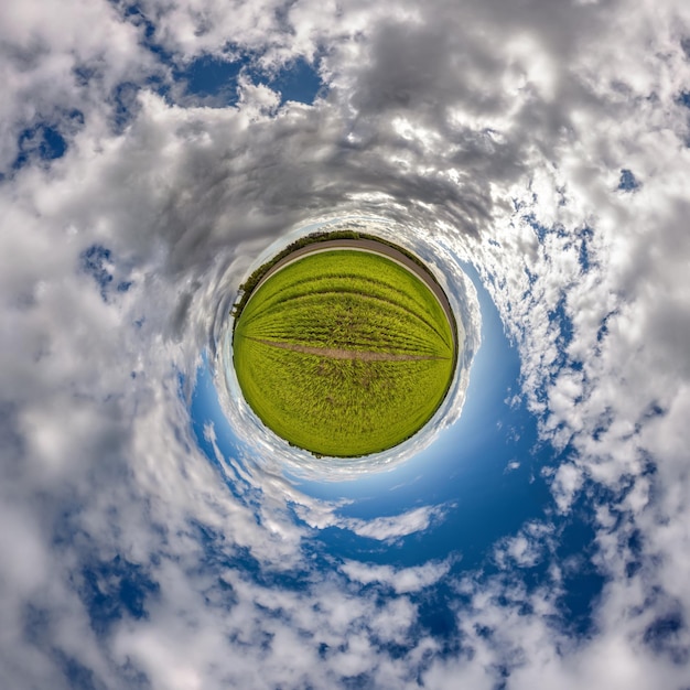 Tiny planet in blue sky with beautiful clouds with transformation of spherical panorama 360 degrees Spherical abstract aerial view Curvature of space